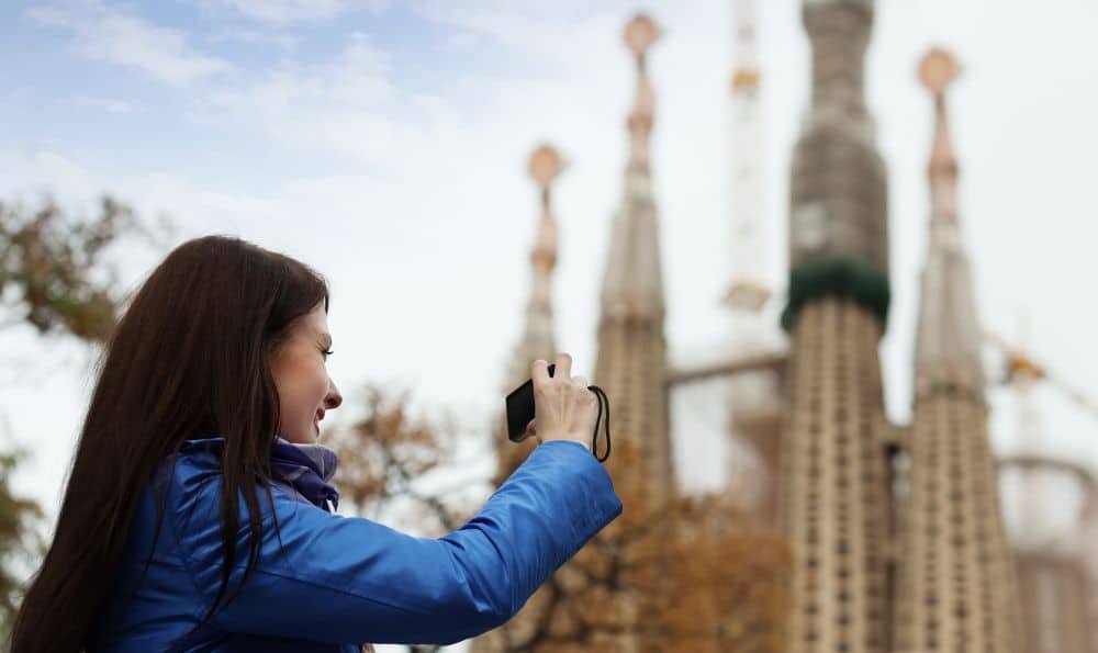 Mujer visitando Barcelona y haciendo una foto a la Sagrada Familia